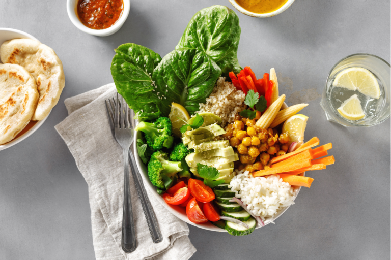 Table place setting with bowl of vegetables and other colorful foods